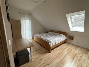 Schlafzimmer mit einem Bett und Holzboden in der Unterkunft SCHÖNE AUSSICHT in Kleinrechtenbach