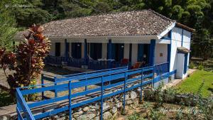 uma pequena casa com uma cerca azul em frente em FAZENDAS ANTIGAS HOTEL em Sumidouro