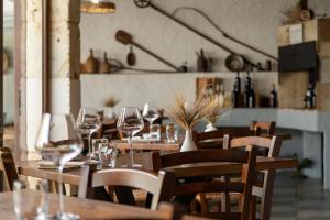 a restaurant with wooden tables and chairs with wine glasses at Agriturismo Casa Marmida in Pardu Atzei