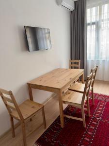 una mesa de madera y sillas en la sala de estar. en Terrace Guesthouse en Estambul