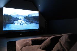 a bedroom with a large screen television in a room at Home Family Cinema in Seclin