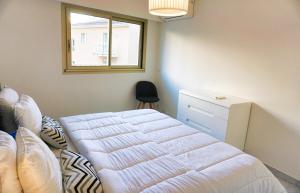 a bedroom with a white bed and a window at Ref LEM4 - Palmes d'Or Properties in Cannes