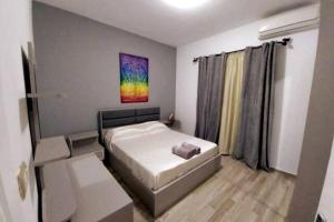 Luxury Getaway /Brand New 2BR /Wi-Fi /Full Kitchen في شرم الشيخ: غرفة نوم صغيرة مع سرير ولوحة على الحائط