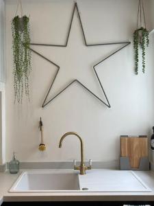 a large white star hanging above a kitchen sink at Top Deck - Fresh, stylish seaside apartment in Ventnor