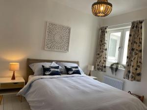 a bedroom with a bed and a chandelier at Top Deck - Fresh, stylish seaside apartment in Ventnor