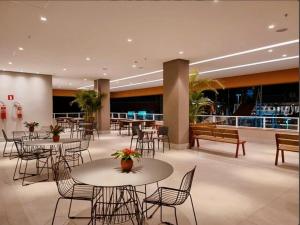 a hotel lobby with tables and chairs and tables and benches at Apartamento Resort Solar das Águas em Olímpia in Olímpia