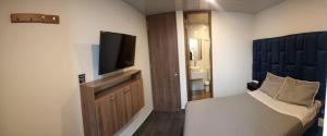 a hotel room with a bed and a flat screen tv at Hotel Everest Chia Oficial in Chía