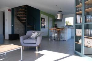 ein Wohnzimmer mit einer Treppe und einem Stuhl sowie eine Küche in der Unterkunft Home Family Cinema in Seclin