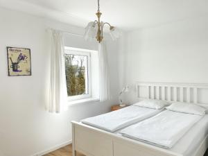 a white bedroom with a bed and a window at Casa Verano by 3City Rentals in Gdynia