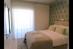 - une chambre avec un grand lit et une fenêtre dans l'établissement Hidden Pearl W/ Patio & Pool by LovelyStay, à Lisbonne