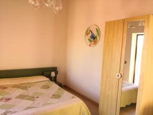 a small bedroom with a bed and a mirror at Agriturismo Il Ranch in Portopalo