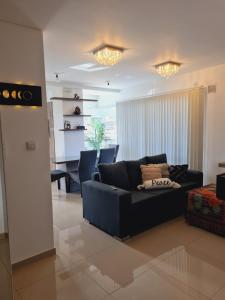 a living room with a black couch in a room at Edificio Leonardo 6to piso in Villa Carlos Paz