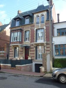 a brick house with a car parked in front of it at Villa D'ALBATRE in Dieppe