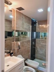 a bathroom with a toilet and a sink and a shower at Edificio Leonardo 6to piso in Villa Carlos Paz