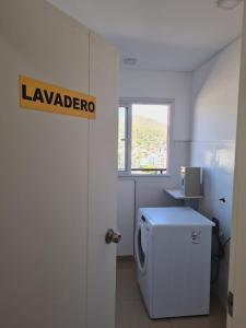 a laundry room with a washing machine and a window at Edificio Leonardo 6to piso in Villa Carlos Paz