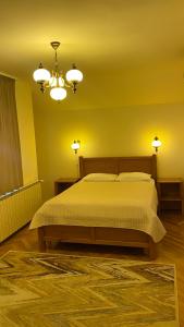 a bedroom with a bed with yellow walls and two lights at Pensiunea Imperial in Târgu-Mureş