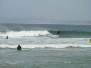 een groep mensen die golven berijden op surfplanken in de oceaan bij Shark's Lodge in Baleal