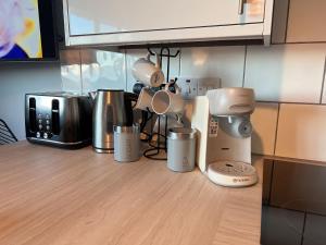 a kitchen counter with various appliances on a table at Beach Court Ground Floor - Cosy Apartment with Sea Views in Saundersfoot