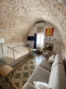 a living room with a couch and a brick wall at Residenza Le Tre Volte - colazione inclusa con TicketBar in Martina Franca
