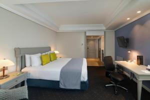 een hotelkamer met een bed en een bureau bij Catalonia Santo Domingo in Santo Domingo