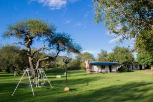 un parque con columpios en el césped en Cabañas Los 2 Algarrobos, en Santa Rosa de Calamuchita
