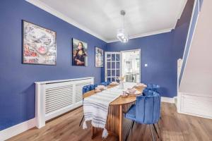 a blue dining room with a wooden table and blue chairs at Victorian Cottage, Close 2 All The Sights, Parking in Windsor