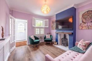 a living room with purple walls and a fireplace at Victorian Cottage, Close 2 All The Sights, Parking in Windsor