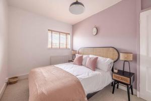 a bedroom with a bed and a clock on the wall at Victorian Cottage, Close 2 All The Sights, Parking in Windsor