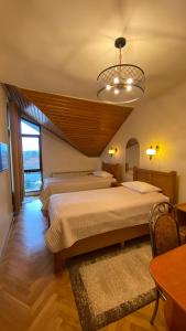 a bedroom with two beds and a chandelier at Pensiunea Imperial in Târgu-Mureş +57 photos