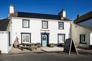 a white building with a picnic table in front of it at Victoria Inn Brewhouse B&B in Roch