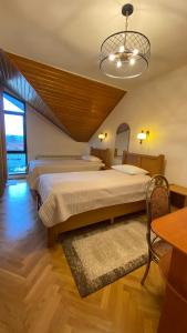 a bedroom with a large bed and a chandelier at Pensiunea Imperial in Târgu-Mureş