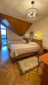 Un dormitorio con una cama grande y una lámpara de araña. en Pensiunea Imperial, en Târgu Mureș