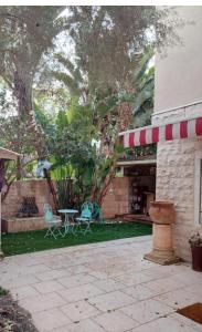 een patio met een tafel en stoelen in een tuin bij דירת מסע בגליל in Bethlehem (Galilea)