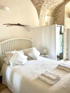 1 dormitorio con 1 cama blanca y 2 toallas en Il Nido, en Castellana Grotte