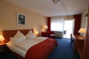 a hotel room with a bed and a desk and a window at Hotel Ännchen in Bad Neuenahr-Ahrweiler