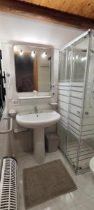 uma casa de banho branca com um lavatório e um chuveiro em Voscenza Benerica em Vittoria
