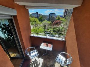 Un balcón con dos sillas y una mesa y una ventana. en Victory apartment, en Niš
