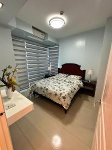 1 dormitorio con 1 cama y 1 mesa con lámpara en The Pearl Interior Designed 1 BR Unit Burgos Circle BGC en Manila