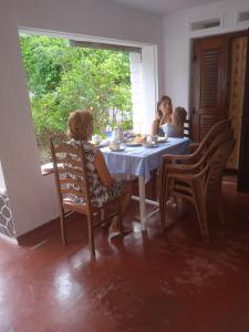 two girls sitting at a table eating food at Sanaya Homestay in Tangalle