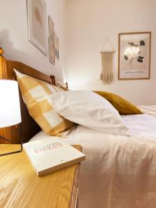 a bed with white sheets and a book on it at Casa Micca - Cielo Terra in San Benedetto del Tronto