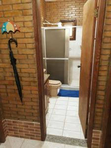 a bathroom with a shower and a toilet and a umbrella at Sítio Completo, na estrada de Aldeia Velha, com rio a frente da porteira in Silva Jardim