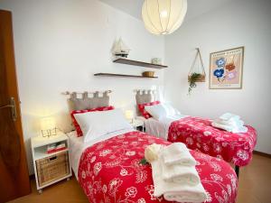 two beds in a room with red and white sheets at Casa Micca - Cielo Terra in San Benedetto del Tronto