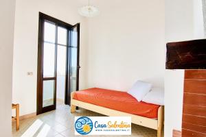 um quarto com uma cama e uma porta para uma varanda em CasaSalentina - Lido Conchiglie em Lido Conchiglia