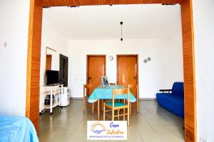 uma sala de estar com uma mesa azul e um sofá em CasaSalentina - Lido Conchiglie em Lido Conchiglia