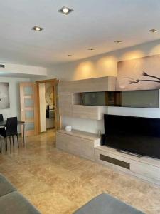 a living room with a large flat screen tv at Frente a Puerto Azahar 2 in Grao de Castellón +9 photos