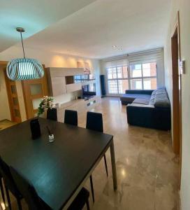 a kitchen and living room with a table and a couch at Frente a Puerto Azahar 2 in Grao de Castellón