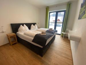 a bedroom with a bed and a large window at Chalet Reiteralm- SKI-IN SKI-OUT in Schladming