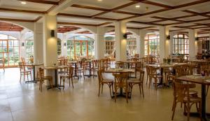 uma sala de jantar com mesas, cadeiras e janelas em Hotel y Departamentos La Serena - Caja Los Andes em La Serena