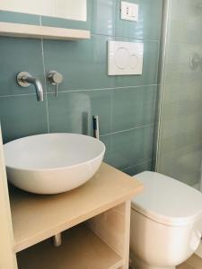 a bathroom with a white sink and a toilet at La Racioppola in Ostuni