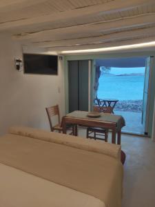 a living room with a table and a view of the ocean at Apanemo Beach House Agios Nikolaos Kimolos in Kimolos